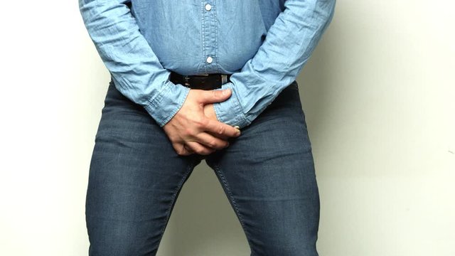 A man is taking a crotch. Pain concept. Impotence. Man Hands Over His Genitals Hurting Crotch Area. Erectile dysfunction. Shot on RED.