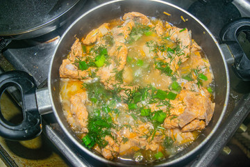 Meat with onions, carrots, dill and Bay leaf is stewed in a saucepan. Home cooking.