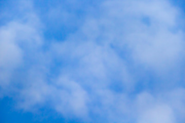 Beautiful white clouds on a background of blue sky. Defocused image for design.