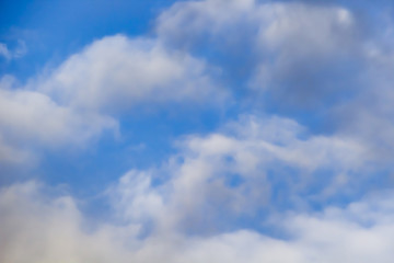 Beautiful white clouds on a background of blue sky. Defocused image for design.
