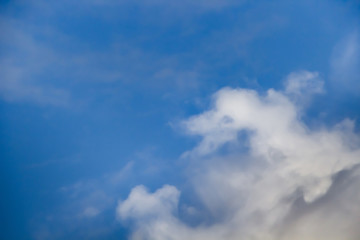 Beautiful white clouds on a background of blue sky. Defocused image for design.