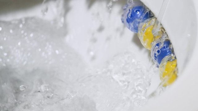 slow motion flushing toilet with rim block toilet cleaner blue and yellow colors