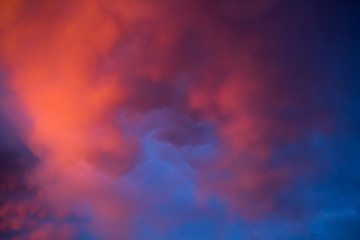Fototapeta na wymiar Unusual pink-purple mammatus clouds at sunset. Blurred image for backgrounds.
