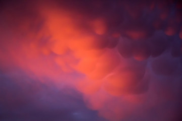 Unusual pink-purple mammatus clouds at sunset. Blurred image for backgrounds.