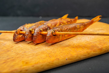 Dried mullet on a wooden Board on the table. Fish and seafood cuisine. Tasty snack.