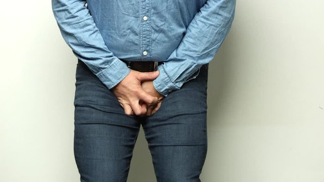 A man is taking a crotch. Pain concept. Impotence. Man Hands Over His Genitals Hurting Crotch Area. Erectile dysfunction. Shot on RED.