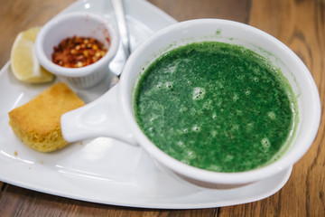 Turkish traditional nettle soup on wooden and white background.Soup with fresh nettles