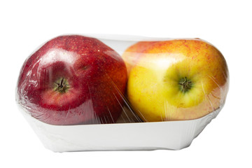 Red and yellow apples in a package on a white background