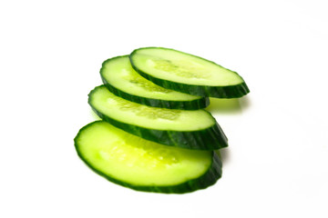 Ripe green cucumber on slices on a white background