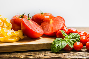 TOMATOES ON A BOARD WITH BASIL AND SPICES
