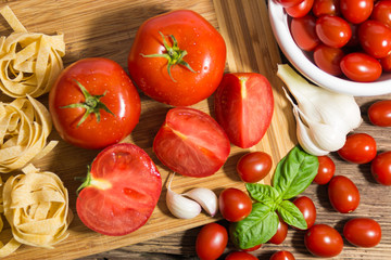 TOMATOES ON A BOARD WITH BASIL AND SPICES