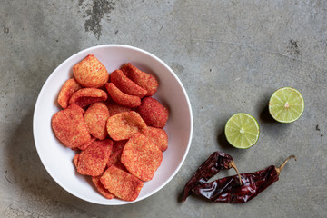 Spicy mexican fried snack garnished with limes and chillis