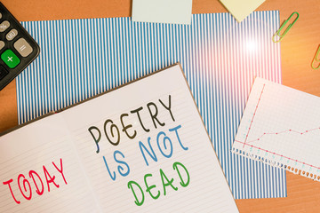 Handwriting text writing Poetry Is Not Dead. Conceptual photo aesthetic and rhythmic writing is still alive and modern Striped paperboard notebook cardboard office study supplies chart paper