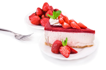 Piece of cheesecake with fresh strawberries and mint leaves isolated on a white background.