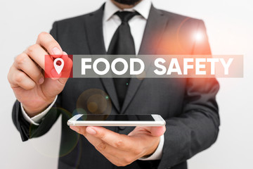 Conceptual hand writing showing Food Safety. Concept meaning conditions and practices that preserve the quality of food Male human wear formal work suit hold smartphone using hand