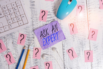 Writing note showing Ask An Expert. Business concept for consult someone who has skill about something or knowledgeable Writing tools and scribbled paper on top of the wooden table