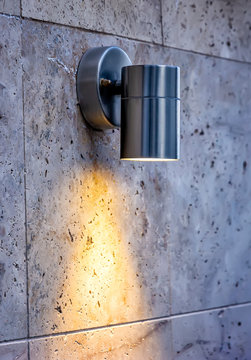 Metal Design Outdoor Spotlight Lamp Lights On A Tiled Wall.