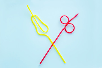 Plastic drinking straw for party or celebration on trendy blue pastel background. Concept summer beach cocktail with straws. Flat lay, top view, copy spase.