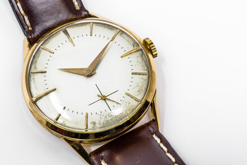 An old gold mechanical wristwatch with manual winding. Antique watch ruined by time, with scratches and mildew stains, rust, oxidation. Leather strap (band). Vintage clock. Spend time.