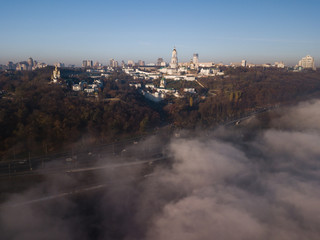 Aerial view Kyiv Pechersk Lavra churches on hills from above with morning fog, Ukraine