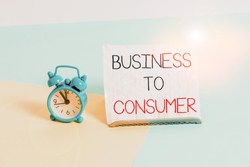 Conceptual hand writing showing Business To Consumer. Concept meaning Direct Transaction between a Company and end users Alarm clock beside a Paper sheet placed on pastel backdrop