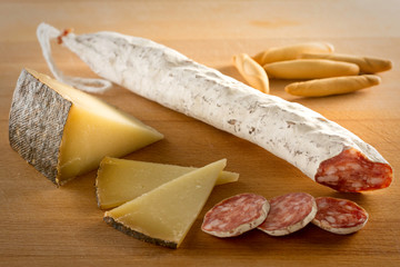 Fuet, queso y picos sobre tabla de madera