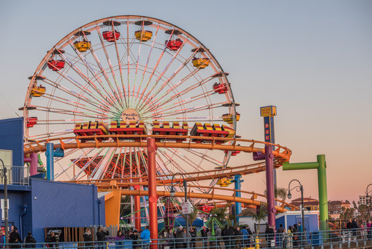 Pacific Park with ferris wheel and roller coaster during sunset