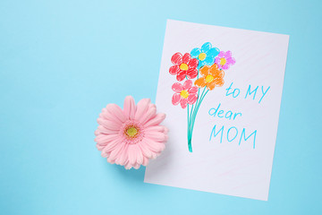 Handmade greeting card for Mother's day and flower on light blue background, flat lay