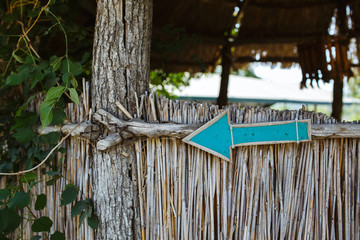 Wooden arrow with blue color pointing to the left.