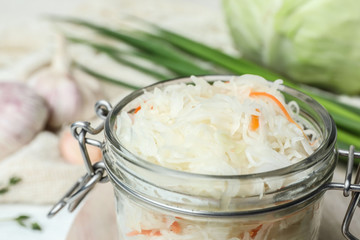 Jar of tasty fermented cabbage on table, closeup