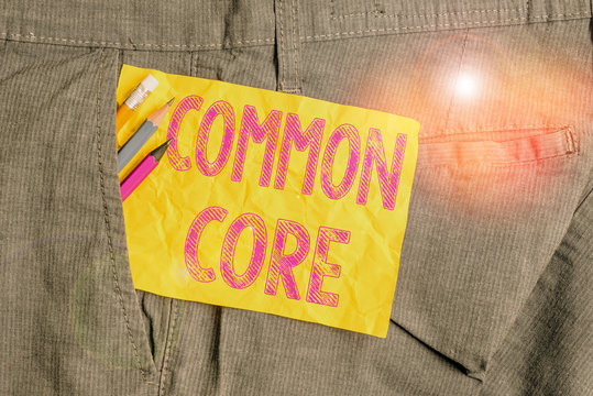 Word writing text Common Core. Business photo showcasing set of academic standards in mathematics and English language Writing equipment and yellow note paper inside pocket of man work trousers