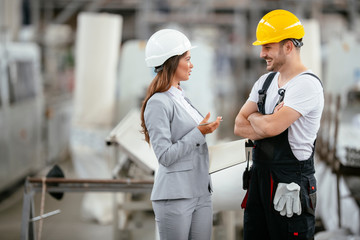 Architect and worker working on project. Colleagues discussing work in factory.