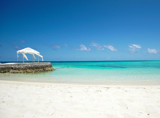 Maldives white sand beach with turquoise water and blue sky