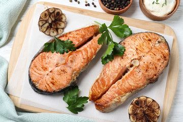Tasty cooked red fish on white wooden table, flat lay
