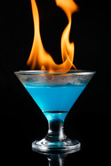 blue alcoholic beverage and fire