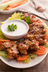 Hot buffalo chicken wings with blue cheese sauce and fresh vegetables.