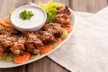 Hot buffalo chicken wings with blue cheese sauce and fresh vegetables.