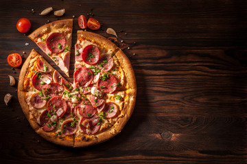 Pizza with salami, ham, bacon, garlic and fresh herbs.