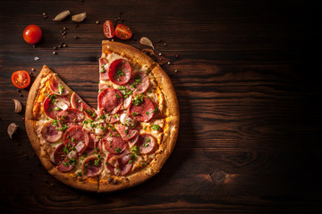 Pizza with salami, ham, bacon, garlic and fresh herbs.