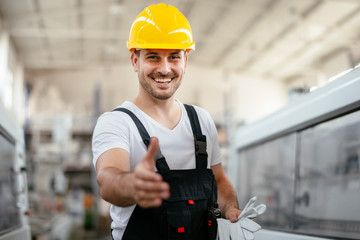 Portrait of worker in uniform gives a hand for handshake  in factory 