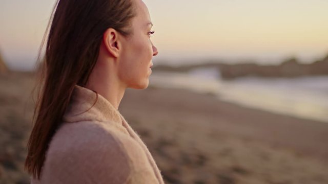 Woman enjoying sunset near ocean