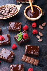 chocolate brownie cake dessert with raspberries and spices on a wooden background.