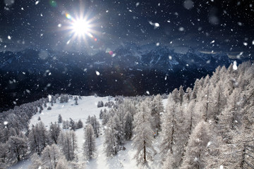Fototapeta premium Christmas background with snowy fir trees and mountains in heavy blizzard.