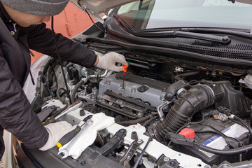 the car mechanic is engaged in repair of cars repair oil change change of wheels polishing of a body