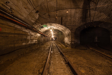 Fototapeta na wymiar Gold iron mine ore shaft tunnel drift with rails underground