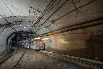 Fototapeta na wymiar Gold iron mine ore shaft tunnel drift with electric locomotive