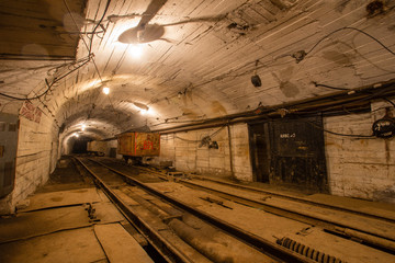 Fototapeta na wymiar Gold iron mine ore shaft tunnel drift with rails car wagon