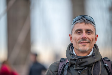 Happy man crossing Brooklyn Bridge in New York City