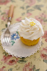 Cupcake with a vanilla frosted swirl in vintage setting