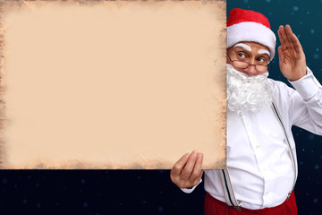 Santa Claus with a beard holds a beautiful blank, blank, old paper poster, cardboard, blank for the designer, pattern for announcements, invitations, greetings, calendar, mock up, close-up, copy space